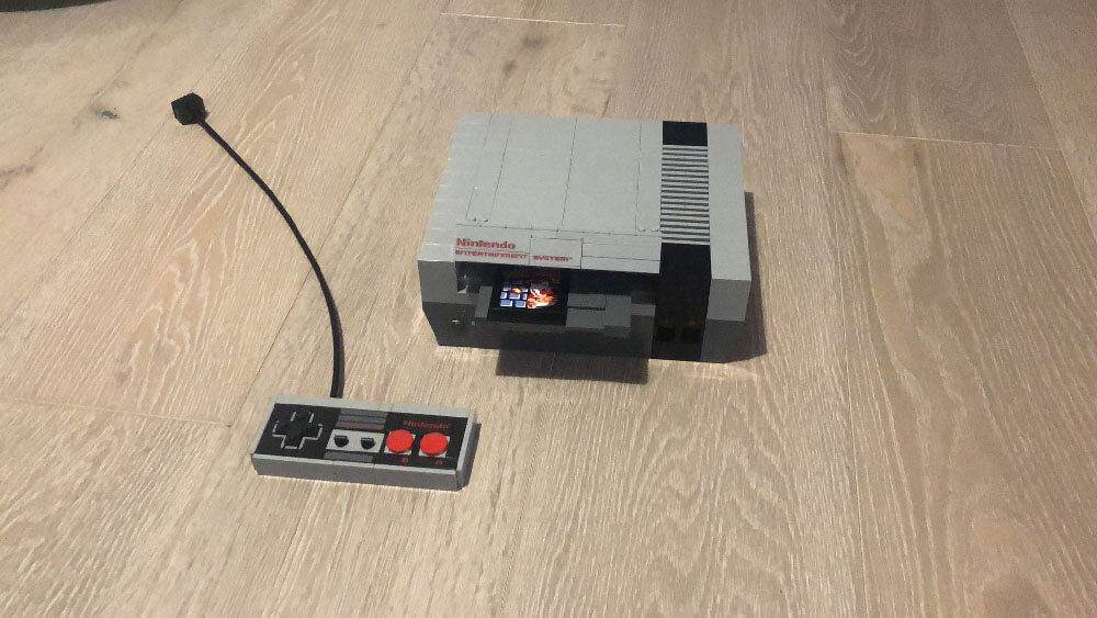A life-size Nintendo Entertainment System console, made out of lego, with a controller (also made out of lego)